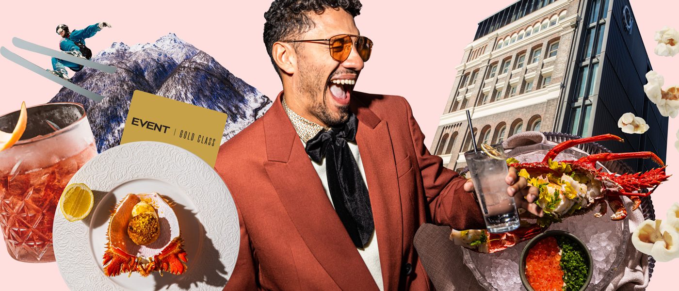 Smiling man in a red suit surrounded by plated food, drinks, herbs, and a city building on a pink background.